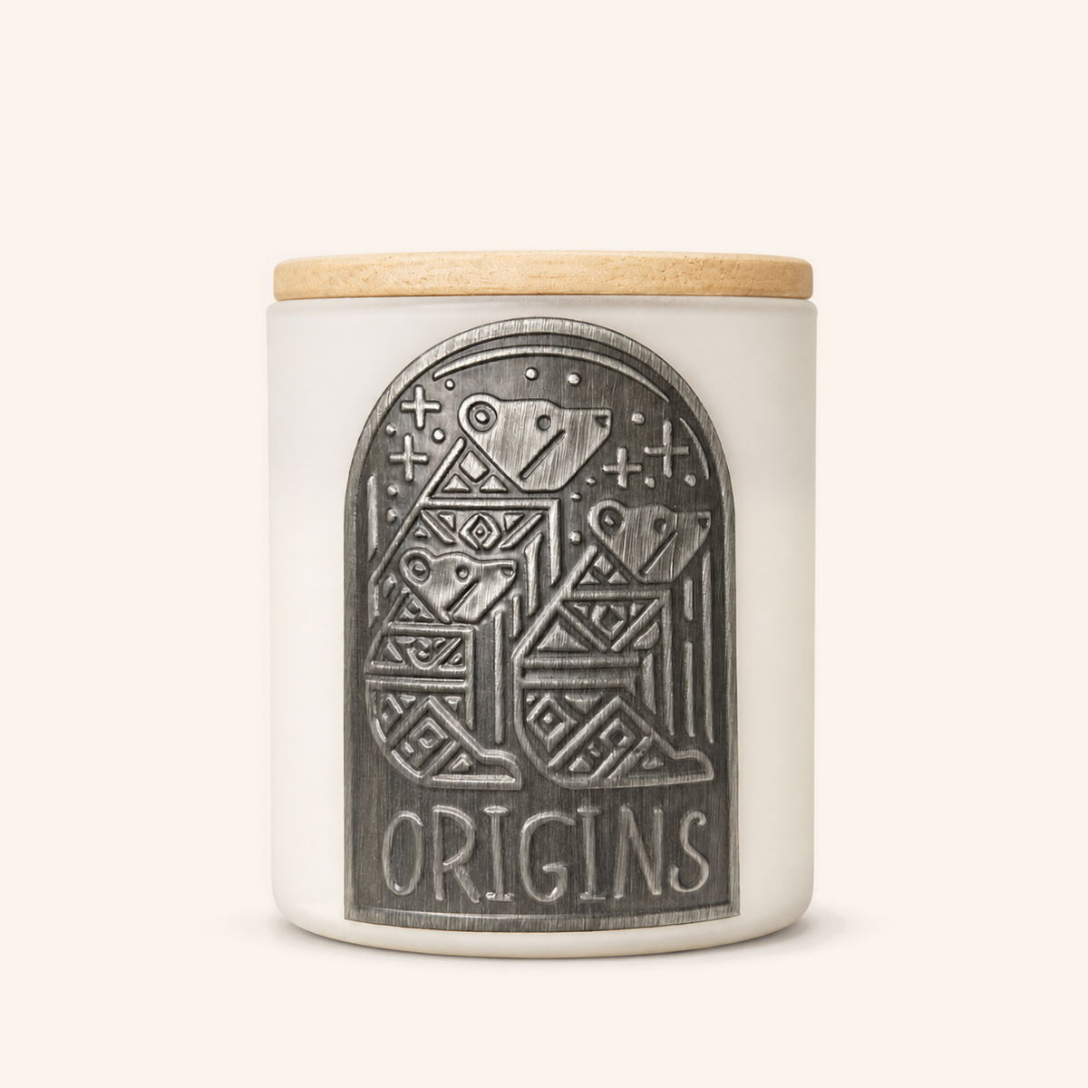 White Origins candle with a wooden lid and raised decorative metal label.