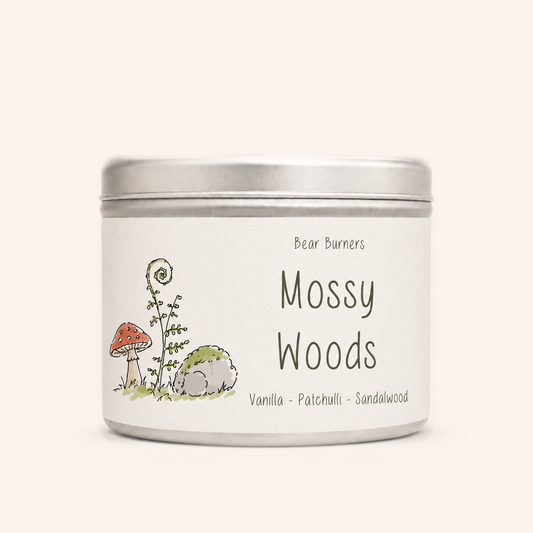 Mossy Woods candle in a silver lidded tin with an illustrated cream label.