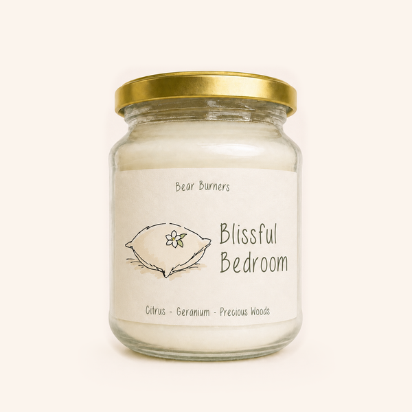 Blissful Bedroom candle in a clear glass jar with a gold lid and illustrated cream label.
