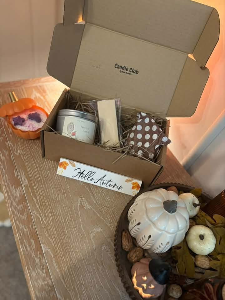 An open Candle Club box styled with autumn pumpkins in a customer's home