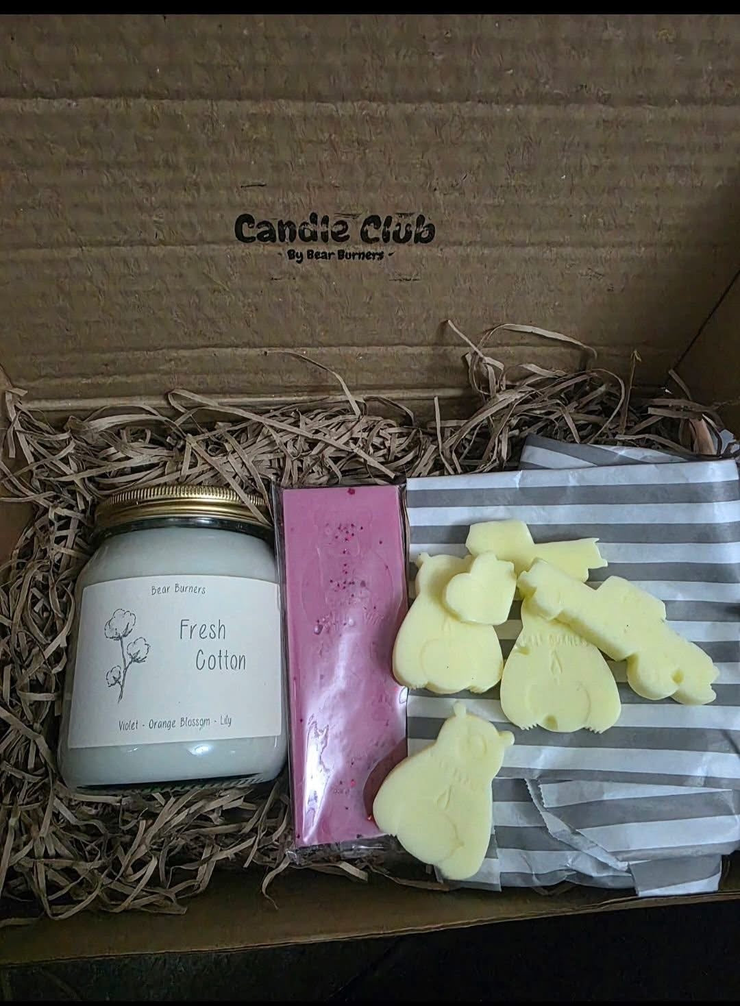 Fresh Cotton candle, pink snap bar and yellow bear wax melts in an open Candle Club box