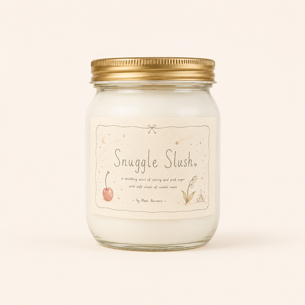 Snuggle Slush candle in a clear glass jar with a gold lid and illustrated cream label.